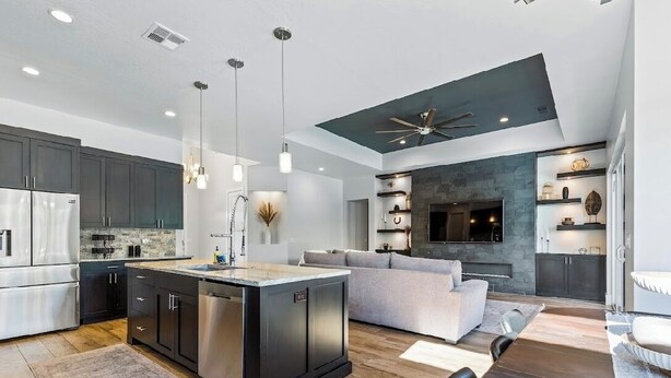 A modern kitchen with dark cabinets, stainless steel appliances, and pendant lighting. - Ivins Oasis : Private Hot Tub & Pool (Ivins)