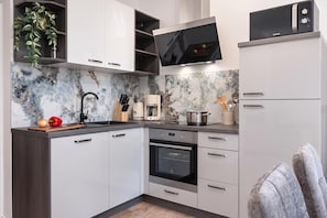 A modern kitchen with white cabinets, a built-in oven, and a microwave. - Seafront Apartment Nana 1, Punat, Croatia (Punat)