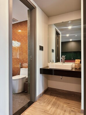 A modern bathroom with a toilet, bidet, and sink. - TUK TAK SPACES (Da Nang)