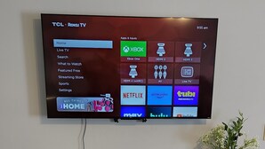 A TCL Roku TV mounted on a wall with a 'hello' sign on a white entertainment center below. - Family Friendly Home~Pets Welcome-Fenced Yard (Clarksville)
