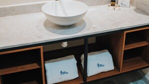A bathroom with a round mirror, a white sink, and two towels with "Casa Puga" branding. - Hotel Casa Puga (Oaxaca)