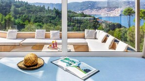 Un balcon avec un canapé, un chapeau et un magazine.