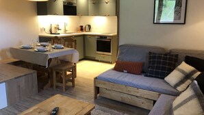 A compact living space with a dining area, kitchenette, and a sofa. - Lauzière Dessus 22 - Crève Coeur (LES AVANCHERS VALMOREL)