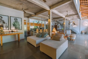 Relax and socialize in this open-plan living space with a central seating area, dining table, and kitchen island.
