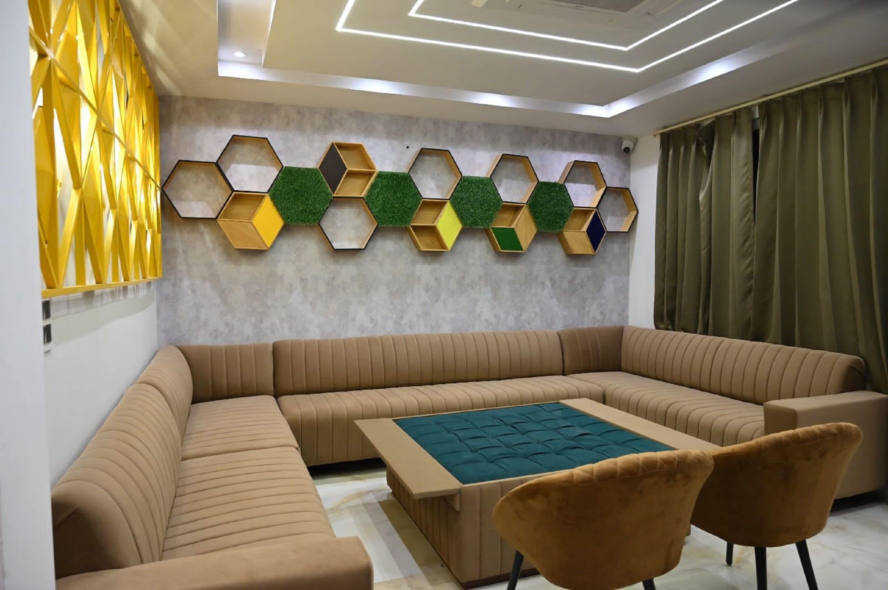 A modern living room with a sectional sofa, a coffee table, and a wall-mounted hexagonal shelf unit.
