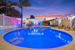 Une piscine avec des chaises longues et un espace patio.