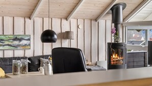 A cozy room with a fireplace, a couch, a table with decorative items, and a painting on the wall. - "Hera" - 200m from the sea by Interhome (Sydals)