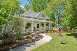 A house with a covered porch, a pathway leading to the entrance, and a small garden area with a birdbath. - King Beds|Pets Welcome|Historic Queen Anne Cottage (Decatur)