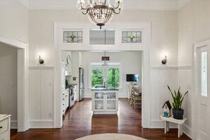A spacious kitchen with white cabinetry, a central island, and a chandelier. - King Beds|Pets Welcome|Historic Queen Anne Cottage (Decatur)