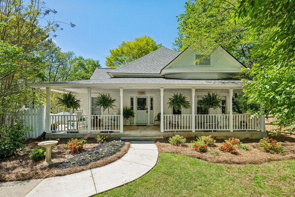 A two-story house with a covered porch, a front yard with a pathway, and a mailbox. - King Beds|Pets Welcome|Historic Queen Anne Cottage (Decatur)