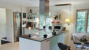 A modern kitchen with a central island, stainless steel appliances, and a view of greenery outside. - "Tume" - 200m from the sea by Interhome (Nexø)