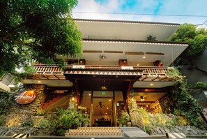 A two-story building with a balcony, stone facade, and potted plants. - Antonio's Bed and Breakfast Hotel (Sorsogon City)