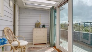 A room with a white dresser, a wicker chair, and a large window with a view of the outdoors. - "Stener" - 250m from the sea by Interhome (Thisted)