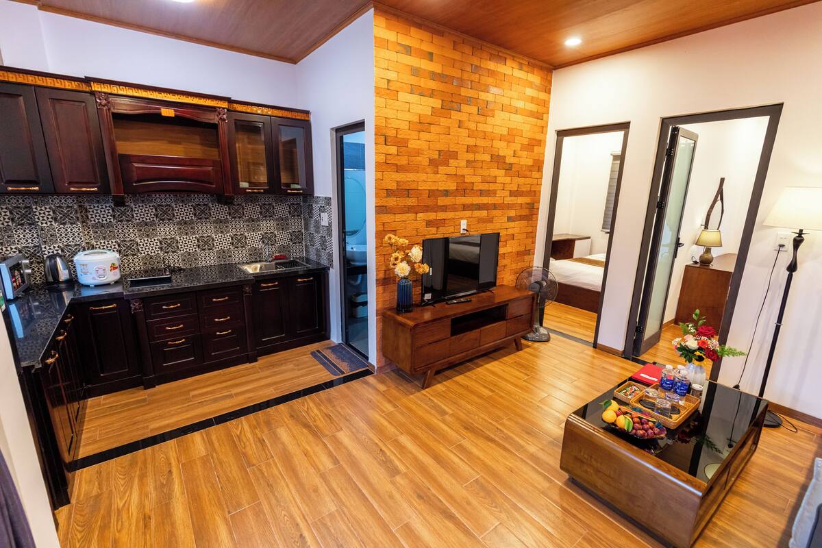 Una cocina moderna con armarios de madera oscura, un salpicadero de azulejos y suelo de madera.