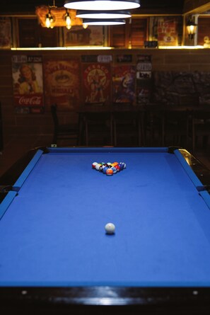 A pool table with balls in the center, a blue felt surface, and a pool cue. - Iris Hill Villa Hue (Hue)