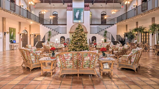 A spacious lobby with a central Christmas tree, multiple seating areas, and a staircase connecting floors. - Naples Resort Retreat w/ Pool Access! (Naples)