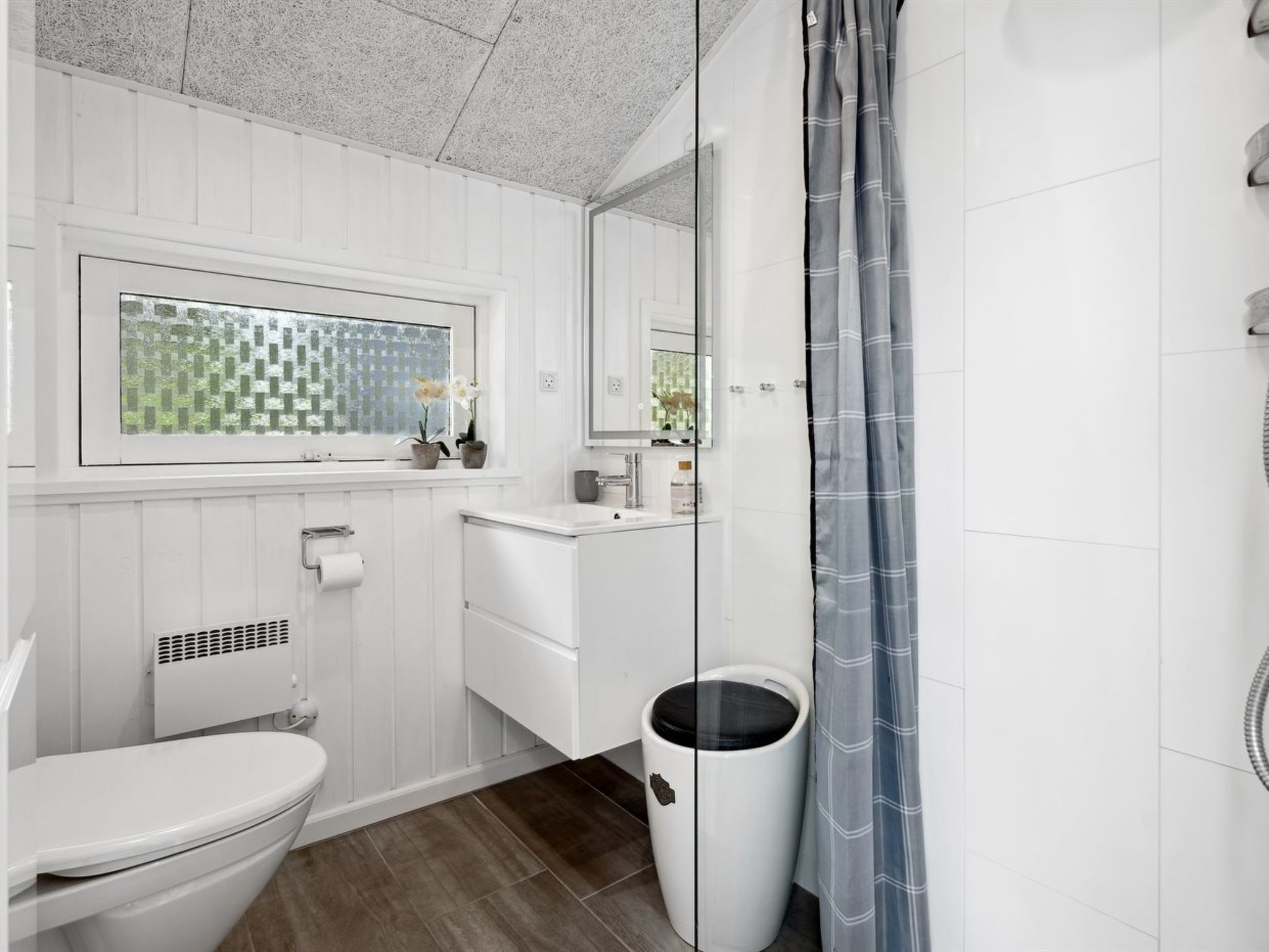 A modern bathroom with a toilet, sink, and shower.