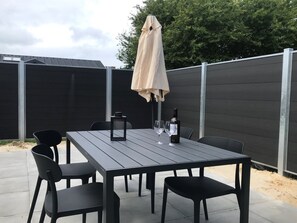 Enjoy dining or socializing in this outdoor patio area with a table and comfortable seating for six.