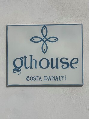 Une enseigne avec les mots « ghouse » et « COSTA DAMALFI » sur un fond blanc.