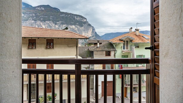 Un balcon avec vue sur des immeubles et une montagne.