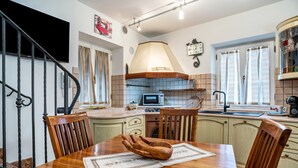 Une cuisine avec une table en bois, des chaises, un four à micro-ondes et un évier.