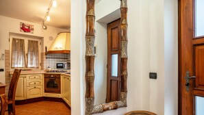 Une cuisine dotée de meubles en bois, d’un four à micro-ondes et d’un coin repas comprenant une chaise et une table.