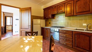 Una cocina con armarios de madera, estufa y refrigerador.
