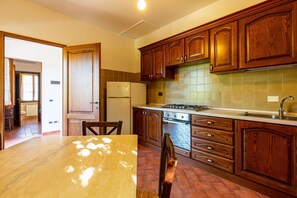 Una cocina con armarios de madera, estufa y refrigerador.