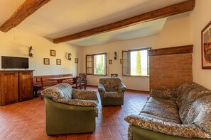 Ein geräumiges Wohnzimmer mit Kamin, Fernseher und Essbereich.