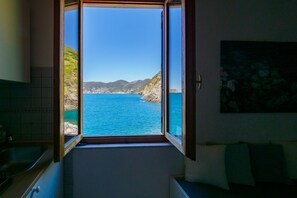 Una habitación con un amplio ventanal que ofrece vistas al mar y a los acantilados.