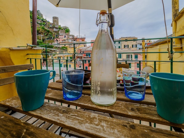 A bottle on a balcony with a view of colorful buildings.