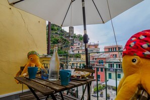 A balcony with a table, a bottle, and plush toys.