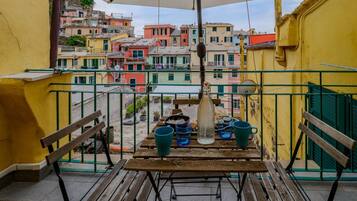 Ein Balkon mit Tisch, Stühlen und einer hängenden Leuchte.