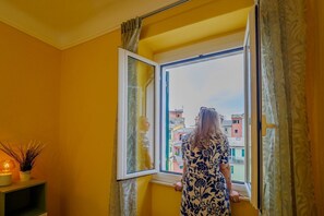 Una habitación con ventana, una planta y una lámpara.