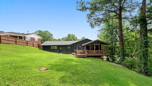 A residential property with a two-story house, a covered porch, and a well-maintained lawn.