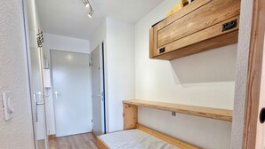 A compact room with a wooden bunk bed, a small wooden shelf, and a white door. - Renovated studio with cabin in Flaine, sunny balcony (Flaine)
