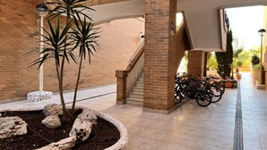 Un vaste espace intérieur avec un mur en briques, un escalier et un sol carrelé.