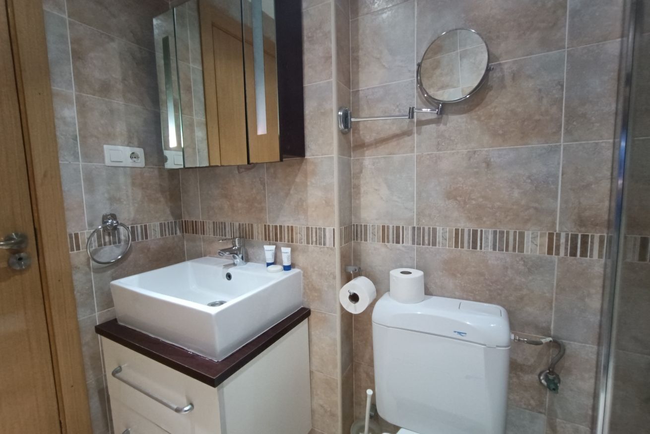 Ein Badezimmer mit Waschbecken, Spiegel, Toilette und Handtuchhalter.