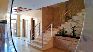 A modern interior with a staircase, a brick wall, and a plant. - ACV - Torremar-2nd line 7th floor Frontal (Oropesa)