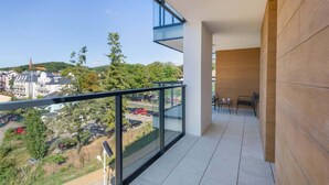 A balcony with a clear view of a parking area and buildings in the background. - Modern Apartment with Balcony | Parking, 450 m to the Beach (Miedzyzdroje)
