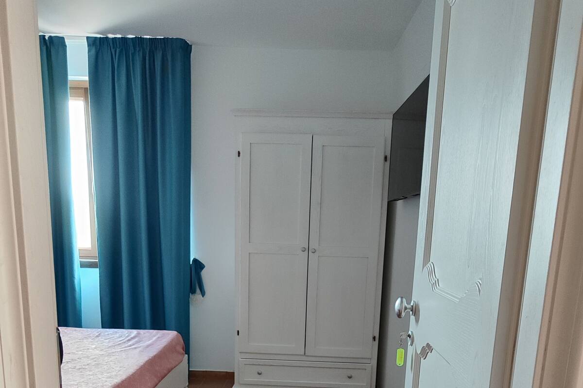 Un dormitorio con cama, armario y puerta.