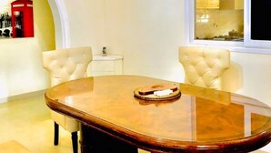 A dining area with a round table, two chairs, a clock, and a window. - Cosy family villa providing a relaxing atmosphere in Tema .Close to restaurants. (Tema)
