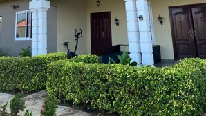 A building with a beige facade, a red roof, and a covered entrance with white columns. - Cosy family villa providing a relaxing atmosphere in Tema .Close to restaurants. (Tema)
