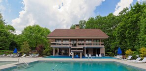 Un bâtiment à deux étages avec une piscine devant.