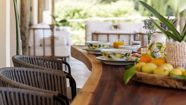A wooden dining table with chairs, a fruit basket, and a vase with flowers. - Villa in Alguazas with 7 bedrooms sleeps 14 (Alguazas)