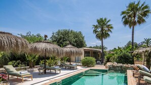 A pool area with lounge chairs, a thatched-roof structure, and palm trees. - Villa in Alguazas with 7 bedrooms sleeps 14 (Alguazas)