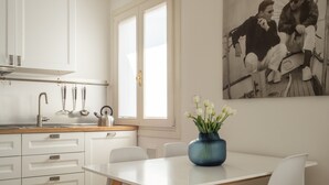 A modern kitchen with white cabinets, a stainless steel sink, and a window with blinds. - Santa Croce Design Apartment R&R (Venecia)