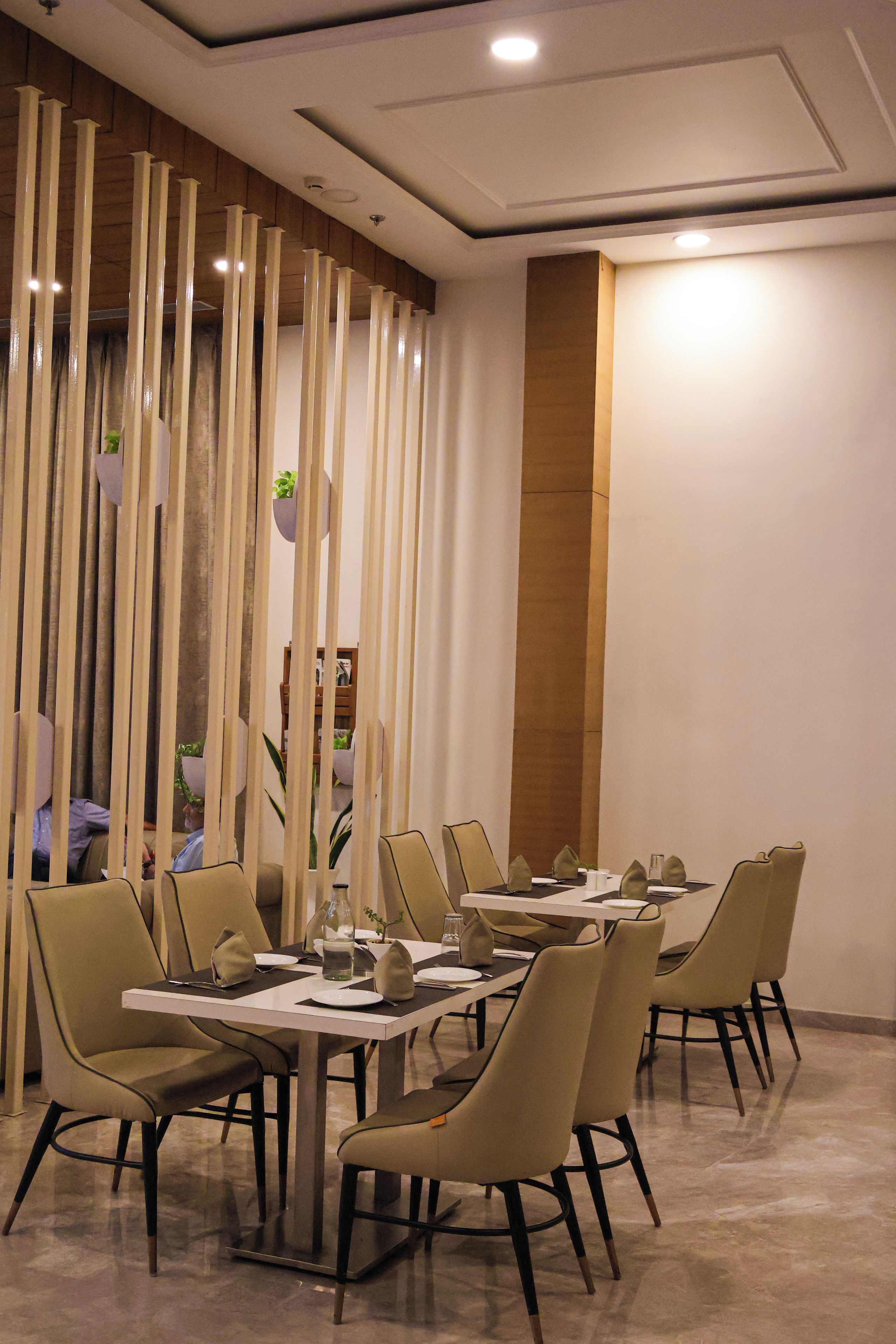 A dining area with a long table set for multiple guests, surrounded by chairs with a modern design.