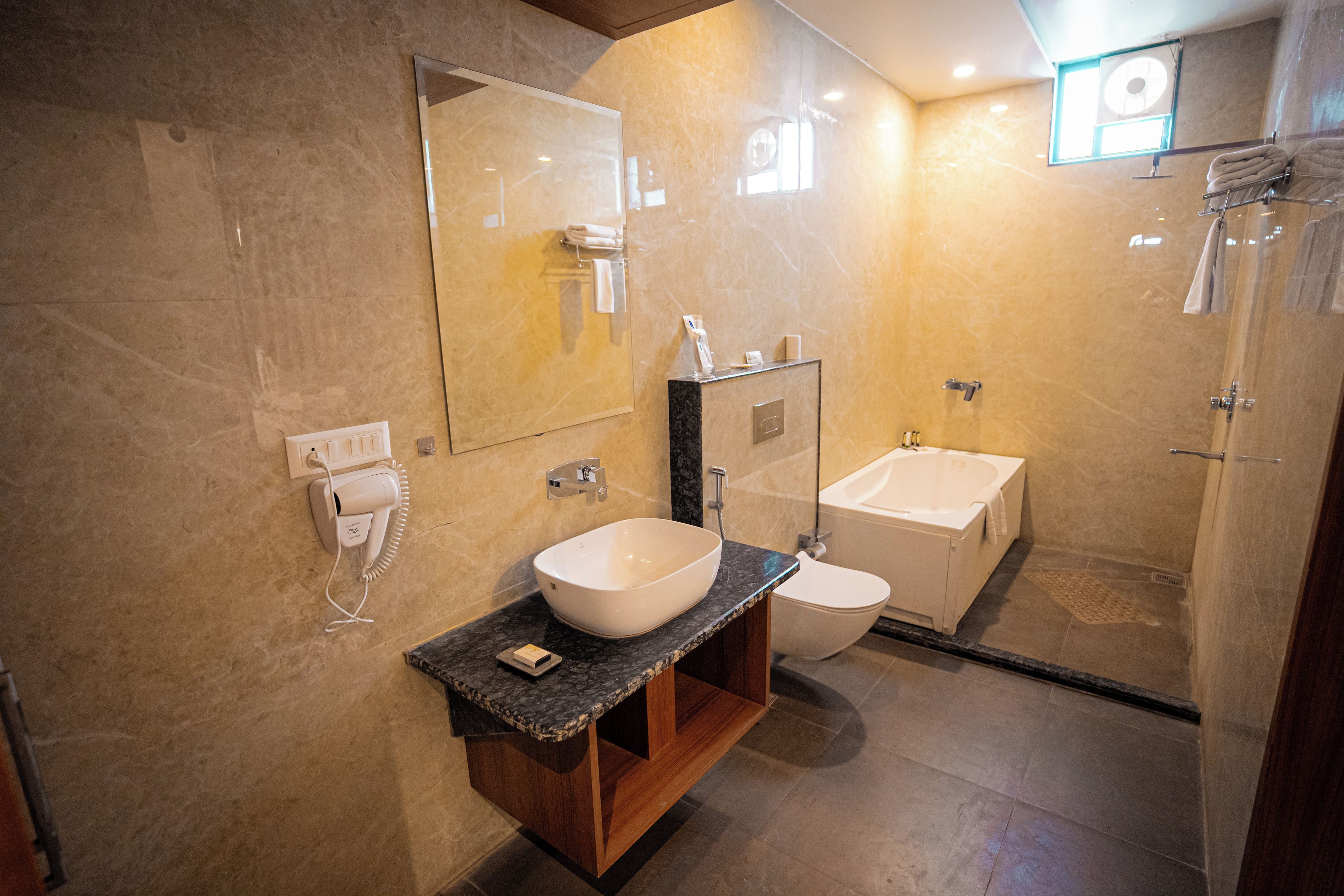 A modern bathroom with a large mirror, a sink, a toilet, and a shower area.