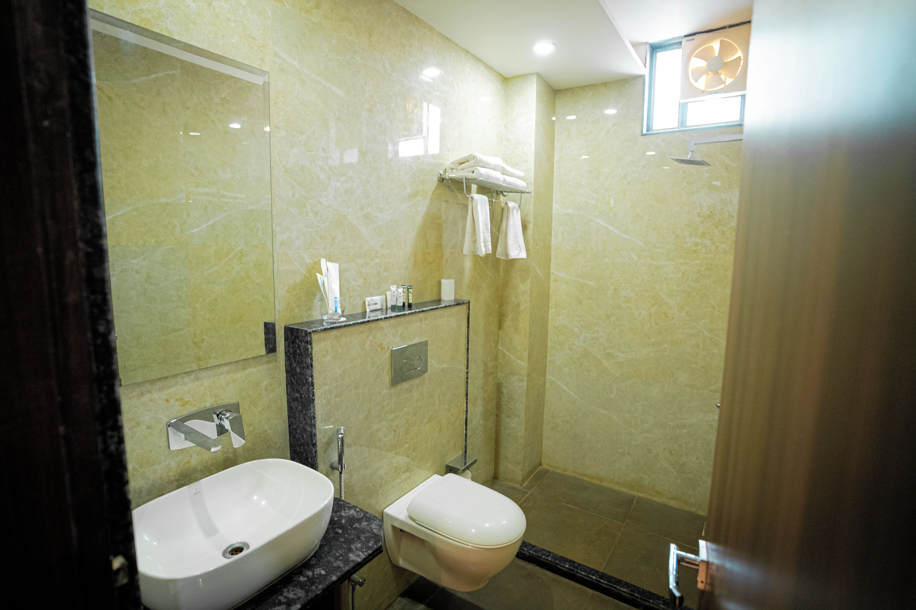 Un baño con lavamanos, inodoro y un perchero para toallas.